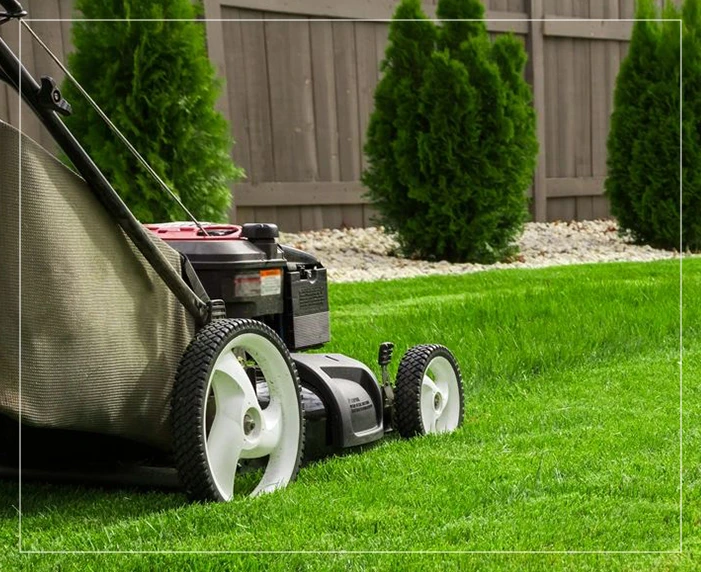 A lawn mower is sitting in the grass.